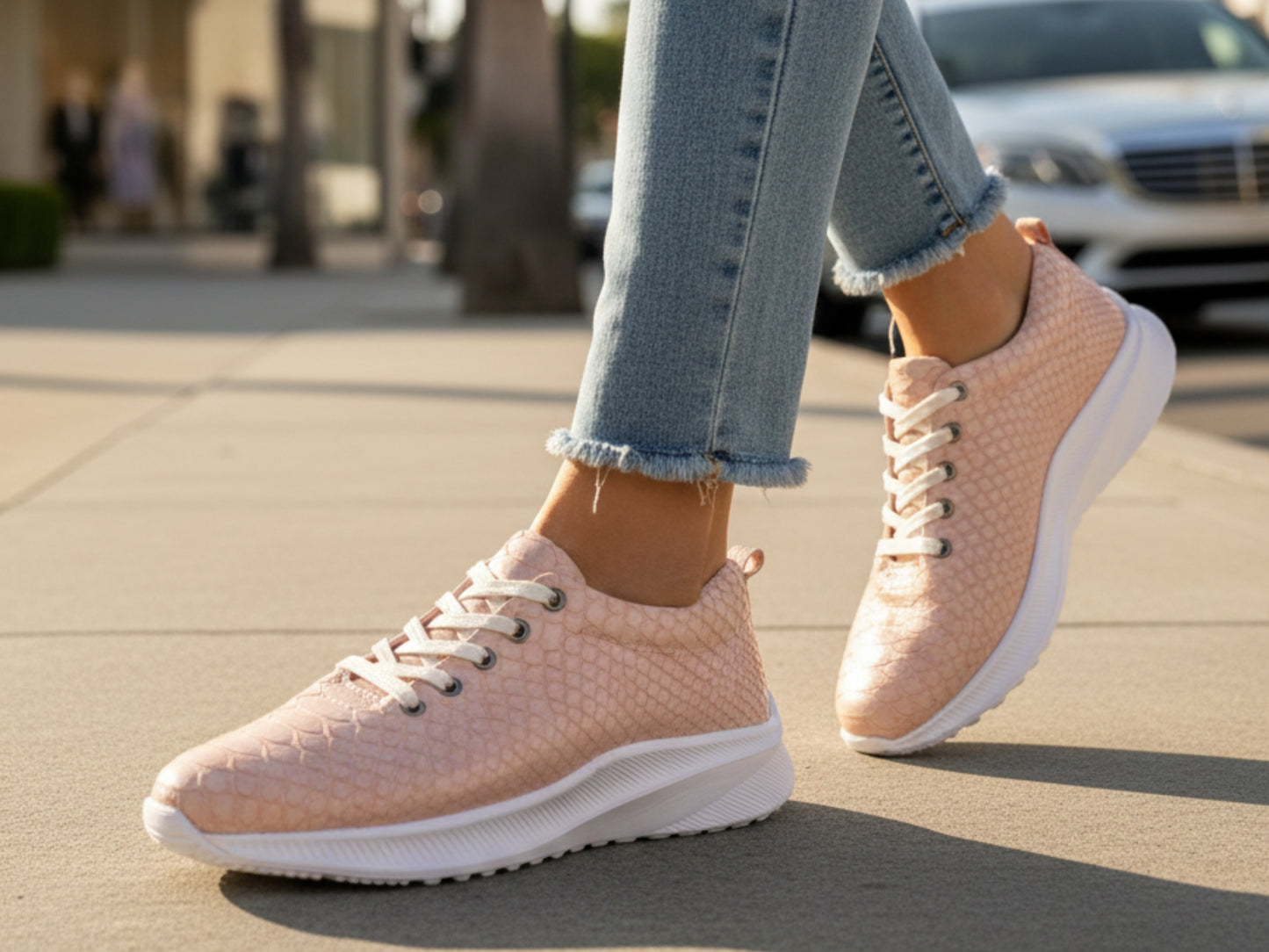 Person wearing pink sneakers with white soles on a sidewalk.