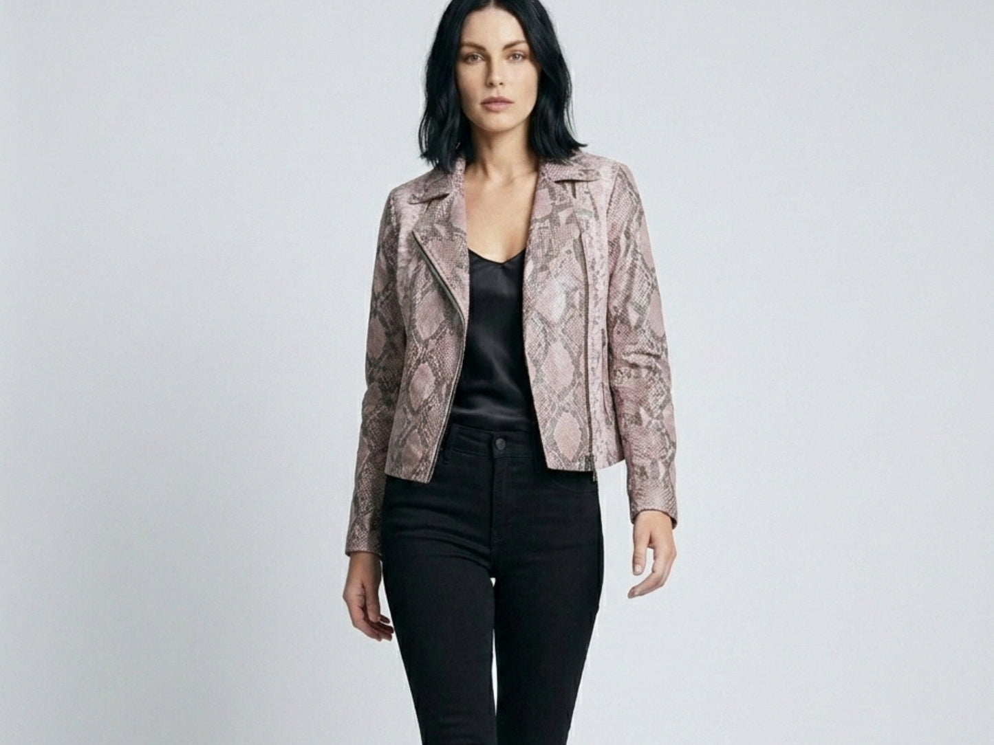 Fashion model walking in pink python snakeskin leather biker jacket on minimalist studio background
