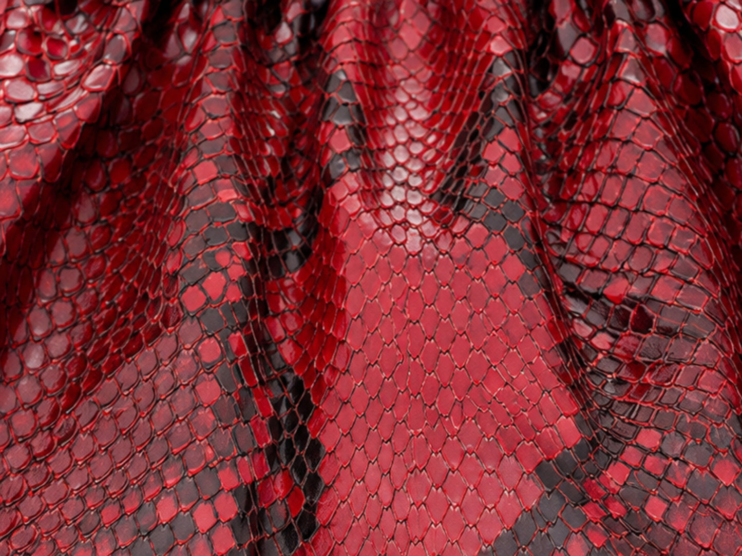 Red and black snakeskin patterned mesh fabric with a glossy, textured scale design.