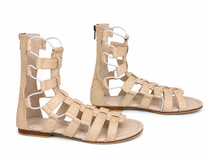 A pair of beige strappy gladiator sandals with textured woven straps and open toes, shown on a plain white background.