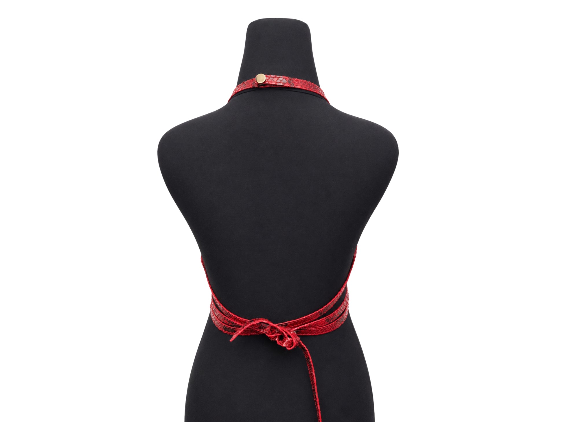 A red patterned halter-style necktie apron with a back waist tie, displayed on a black mannequin torso against a white background.