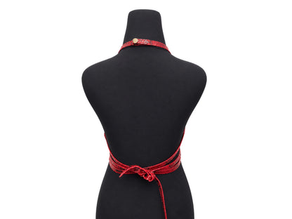 A red patterned halter-style necktie apron with a back waist tie, displayed on a black mannequin torso against a white background.