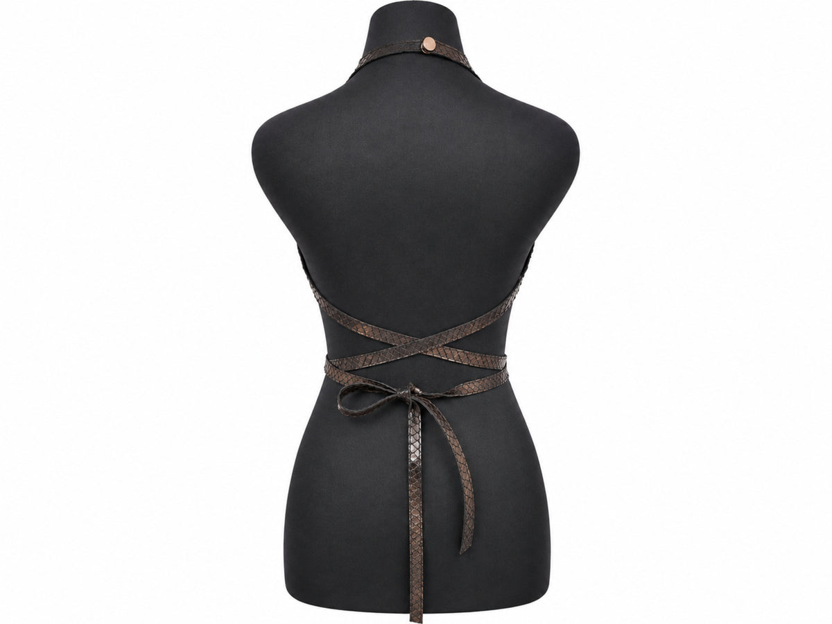 A black dress form mannequin displaying the back of a dark brown woven wrap apron with criss-cross straps and a tie belt.