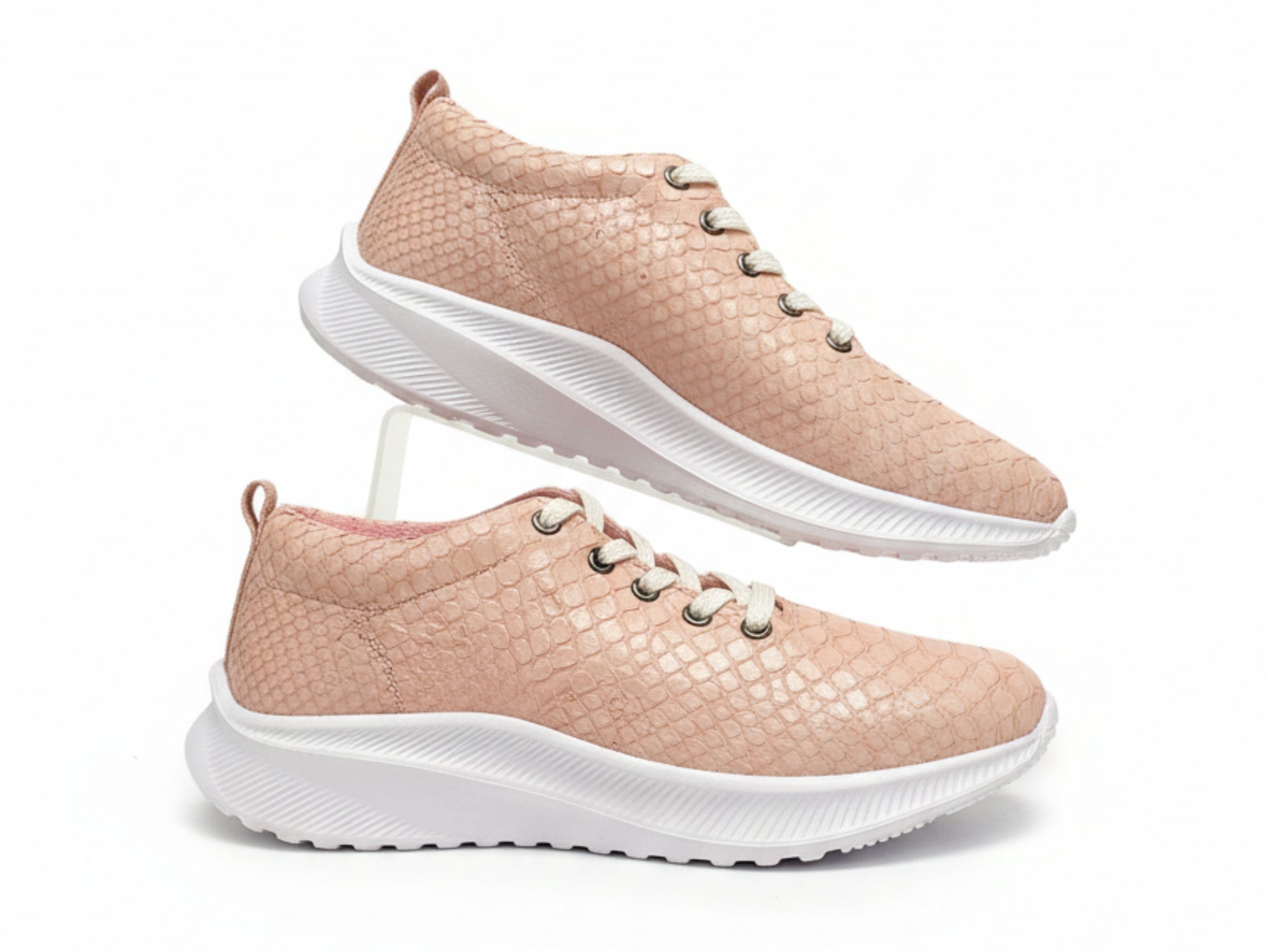 Pair of pink sneakers with white soles on a white background