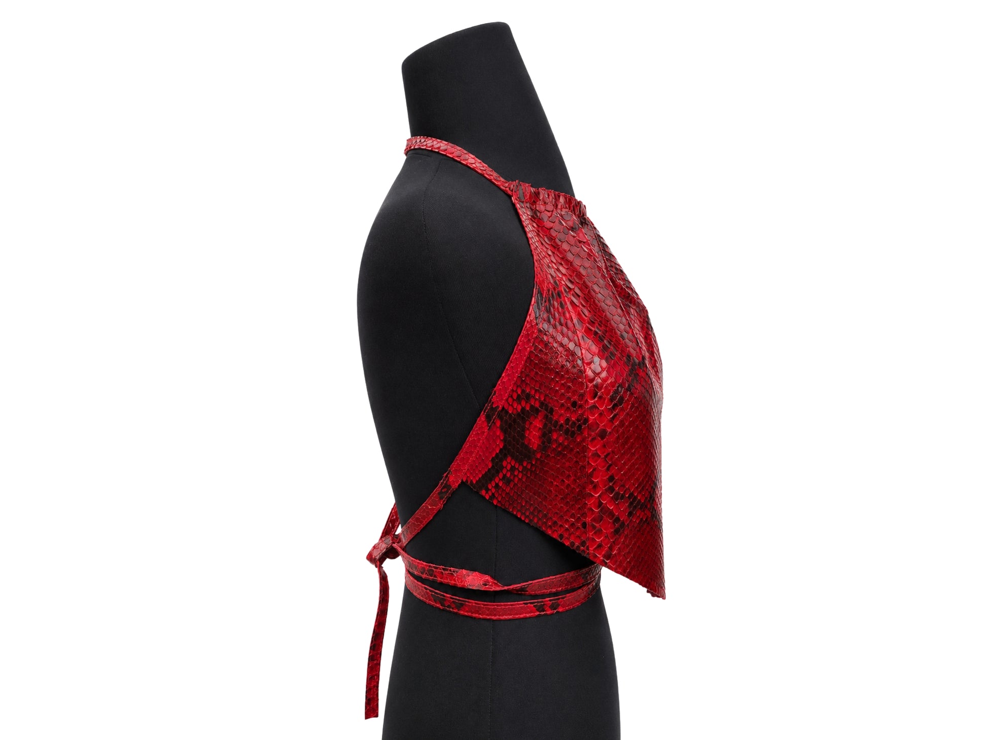 A red snakeskin-patterned halter crop top displayed on a black mannequin torso against a white background.