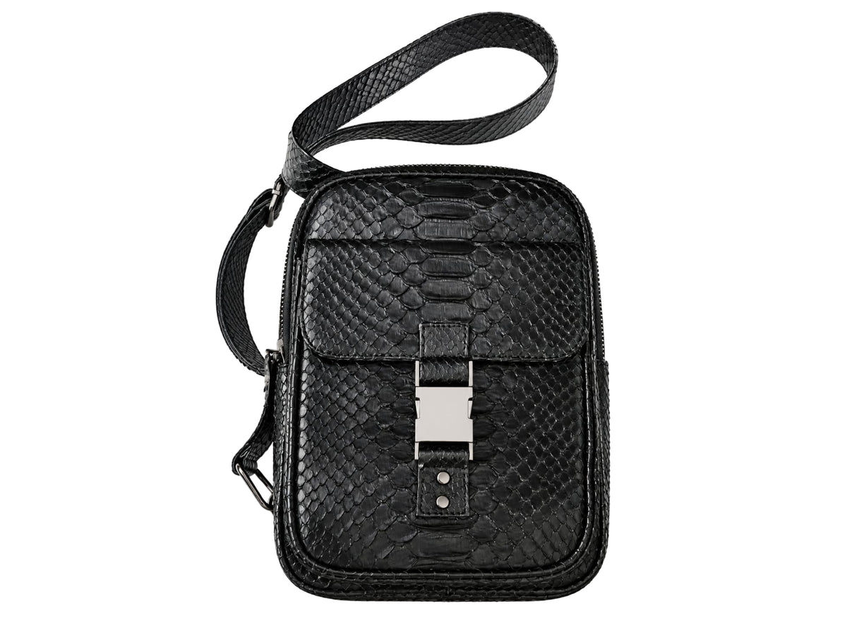 Black textured leather crossbody bag with a python-style pattern, featuring a front flap with a silver-tone metal buckle and a matching black shoulder strap, shown on a plain white background.