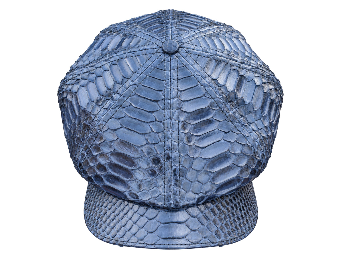 A structured six-panel cap with a flat brim, crafted from navy blue python skin with a prominent scale pattern, shown against a plain white background.