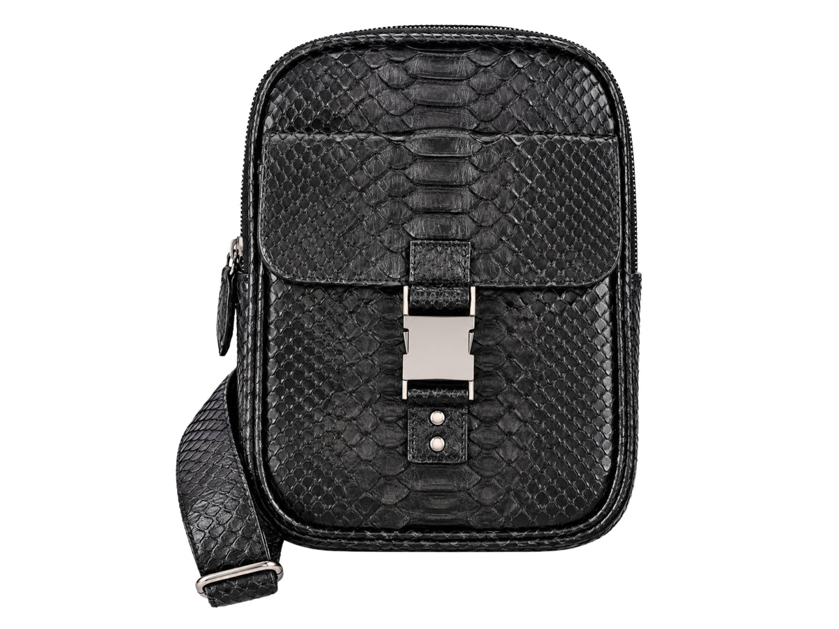 Black python-textured leather crossbody bag with a front flap, silver-tone buckle, and matching shoulder strap, shown on a plain white background.
