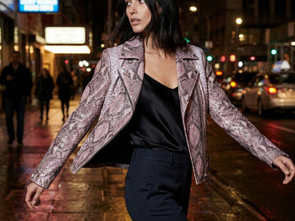 Street style fashion model wearing pink python snakeskin moto jacket at night in city lights