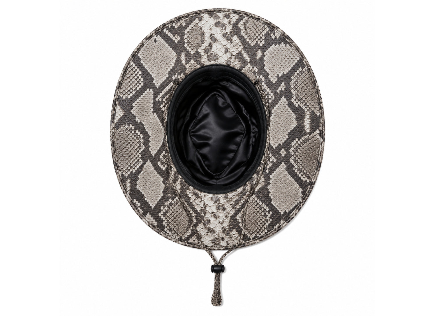 A top-down view of a wide-brimmed cowboy hat featuring a gray and beige snakeskin pattern, with a black satin-lined interior and a black chin strap with a tassel.