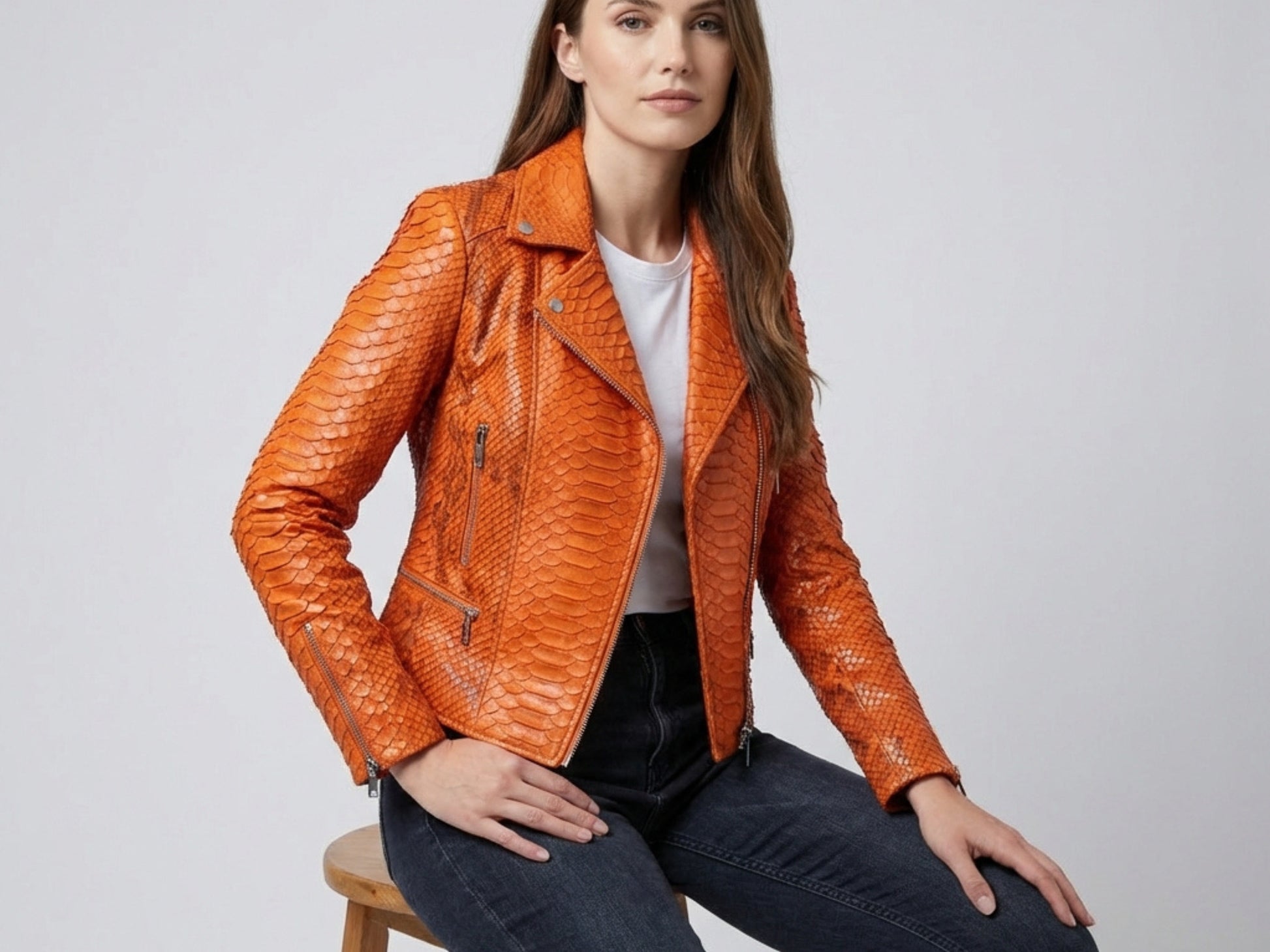 Genuine Python Snakeskin Leather Biker Jacket in Burnt Orange worn by a model sitting on a stool.