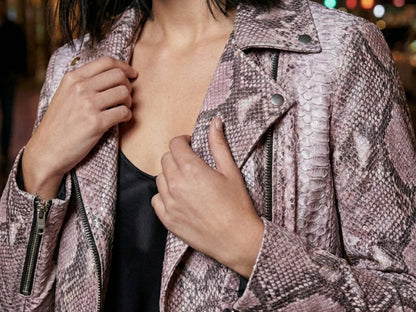 Close up detail of pink python snakeskin leather moto jacket texture with zipper accents