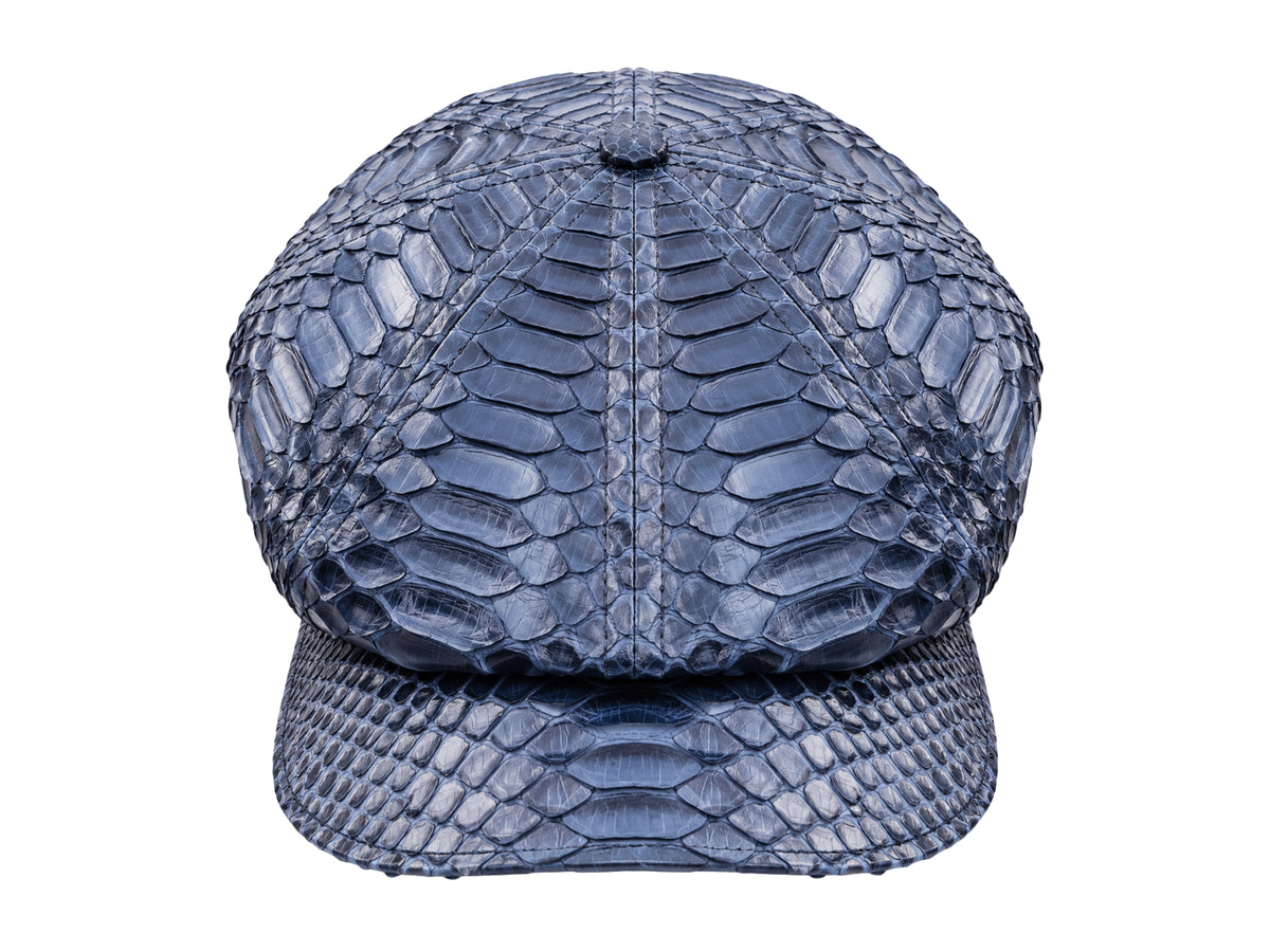 A structured newsboy cap with a navy blue python or snake skin texture, shown against a plain white background.