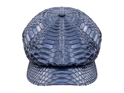 A structured newsboy cap with a navy blue python or snake skin texture, shown against a plain white background.