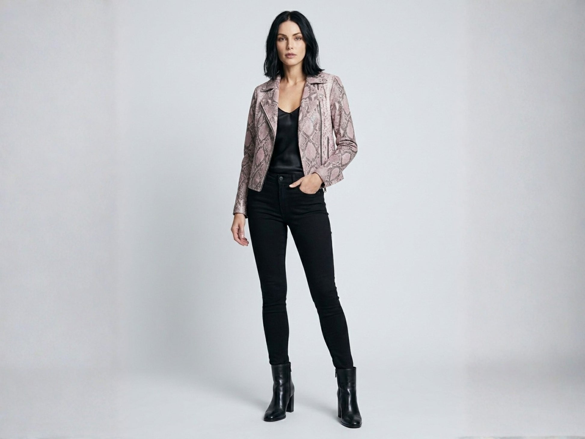 Full body studio portrait of model wearing pink python snakeskin moto jacket with black outfit