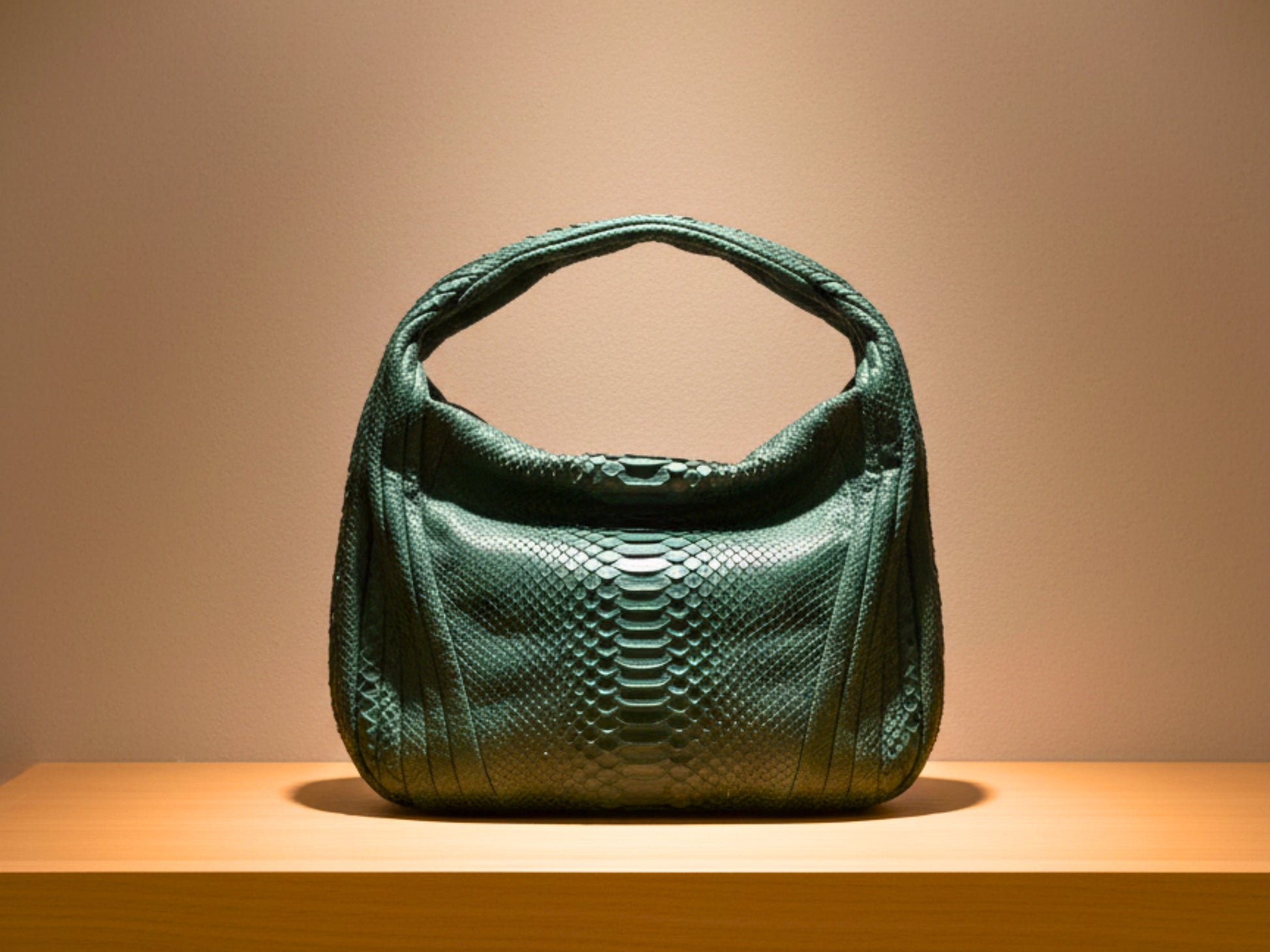 Green textured handbag on a wooden surface with a beige background