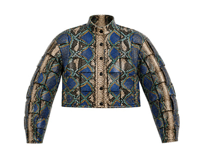 A cropped button-front jacket featuring a bold geometric pattern of blue diamonds and black snakeskin scales on a beige background, presented on a solid white background.