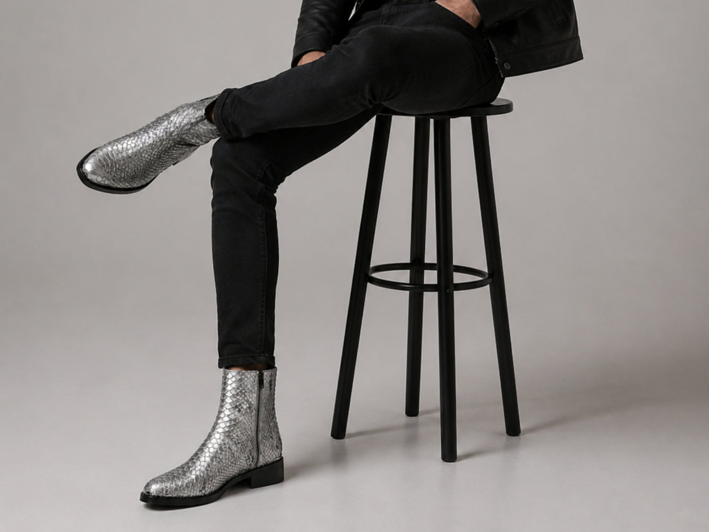 Man wearing silver gray genuine python snakeskin boots with black jeans in a fashion setting
