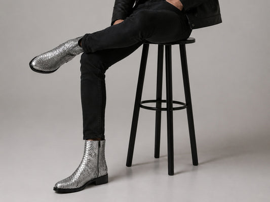 Man wearing silver gray genuine python snakeskin boots with black jeans in a fashion setting