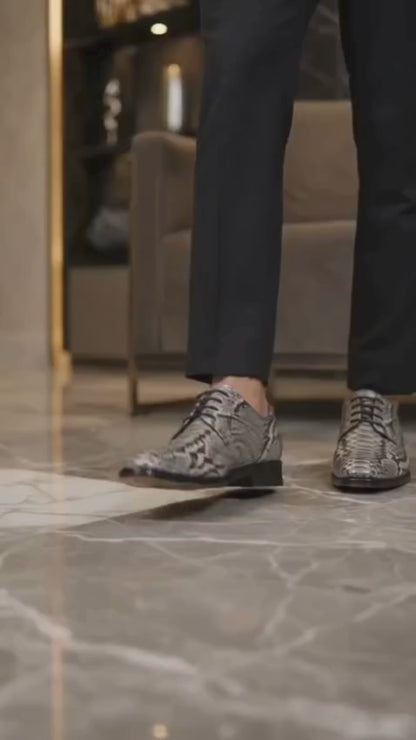 Man wearing genuine python snakeskin dress shoes with black trousers in a luxury interior