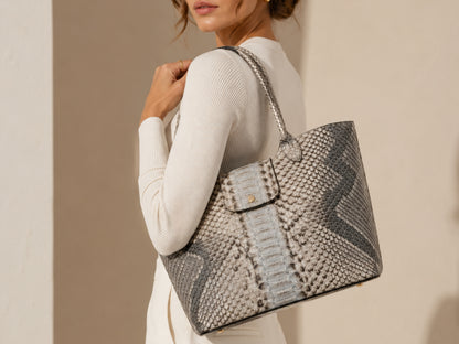 Woman wearing a silver gray genuine python snakeskin shoulder bag over her shoulder showing rear bag profile and natural scales