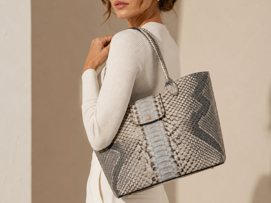 Woman wearing a silver gray genuine python snakeskin shoulder bag over her shoulder showing rear bag profile and natural scales